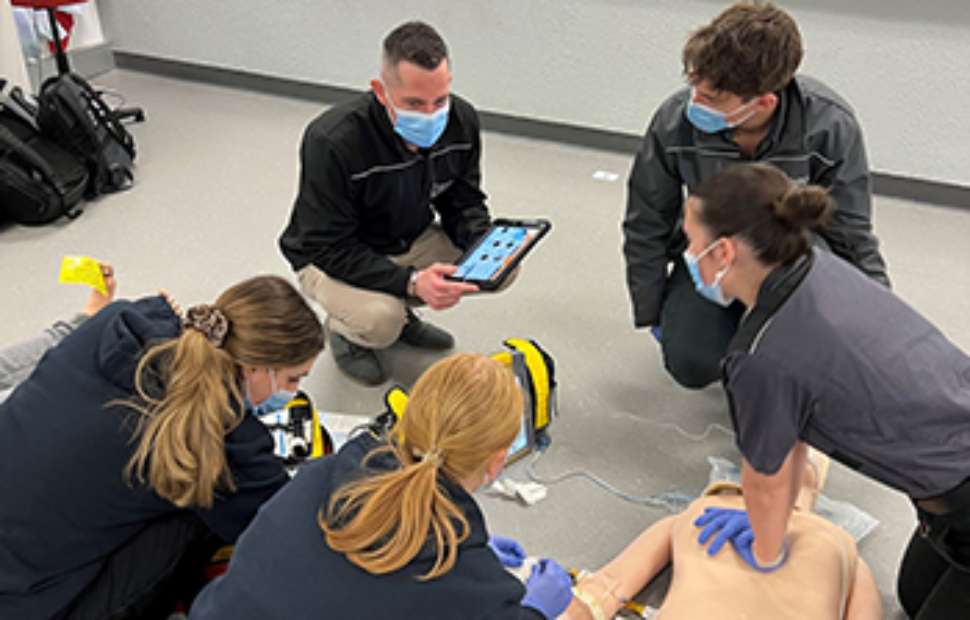 Students practice CPR on dummy