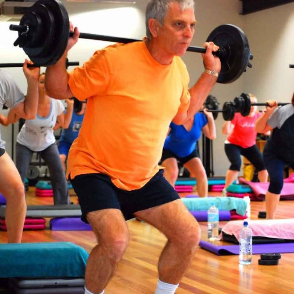 Man liftting weights in fitness class