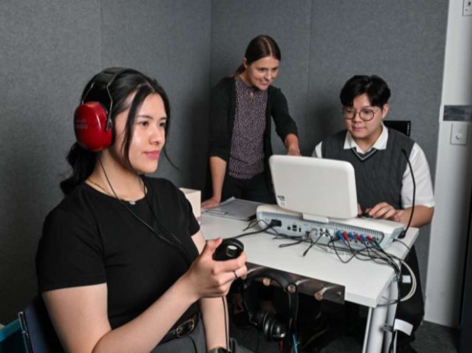 Flinders audiology student on equipment with patients with over ear headphones, performing tests