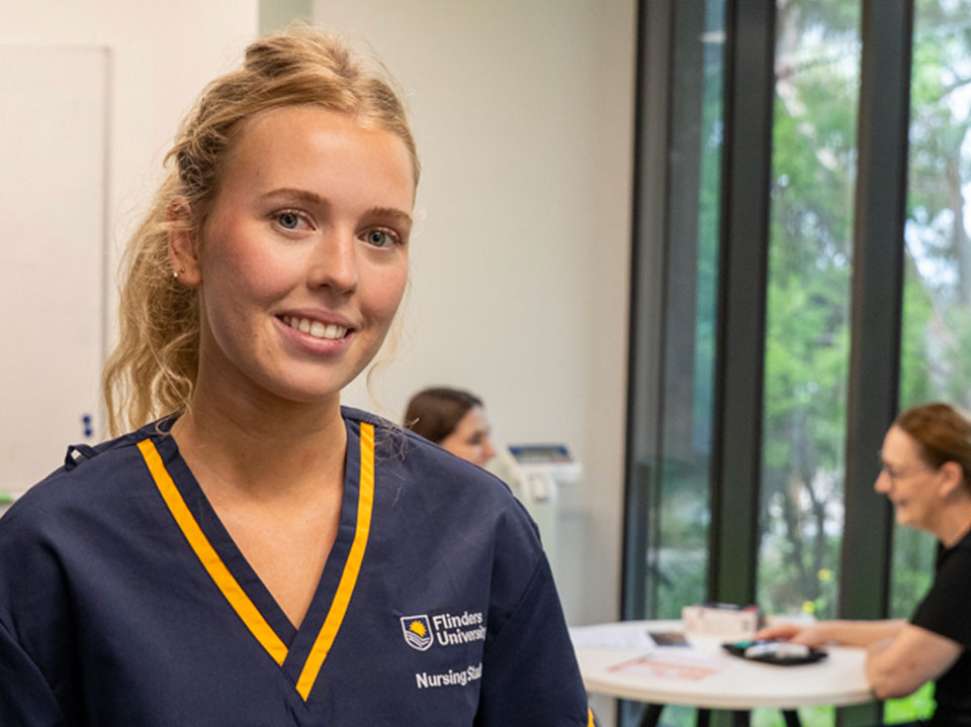 Flinders Nursing student with diabetes patient sitting and smiling in background
