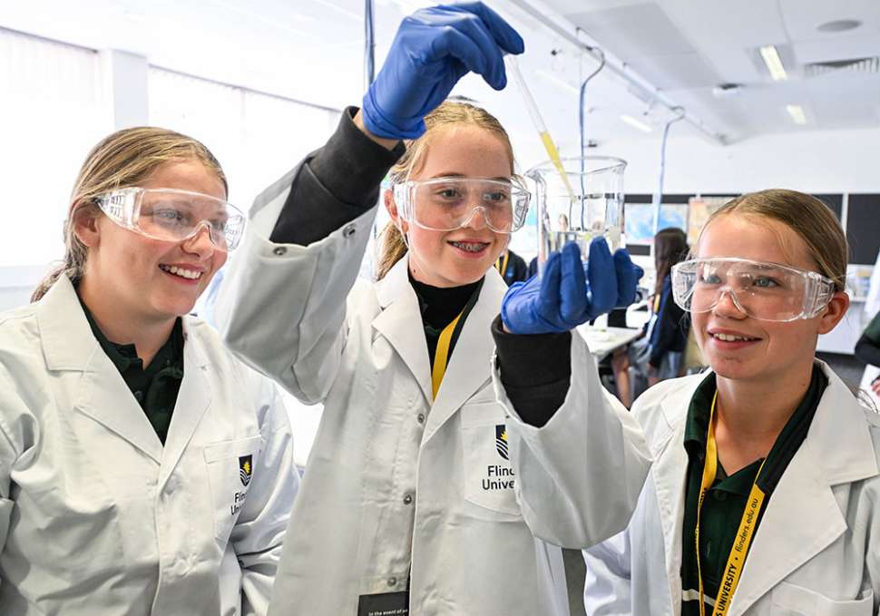 3 year 9 girls doing an experiment at a STEM event